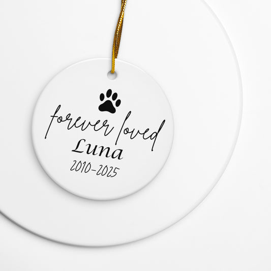Ceramic ornament with paw print and text 'forever loved Luna 2010-2025' on a white background