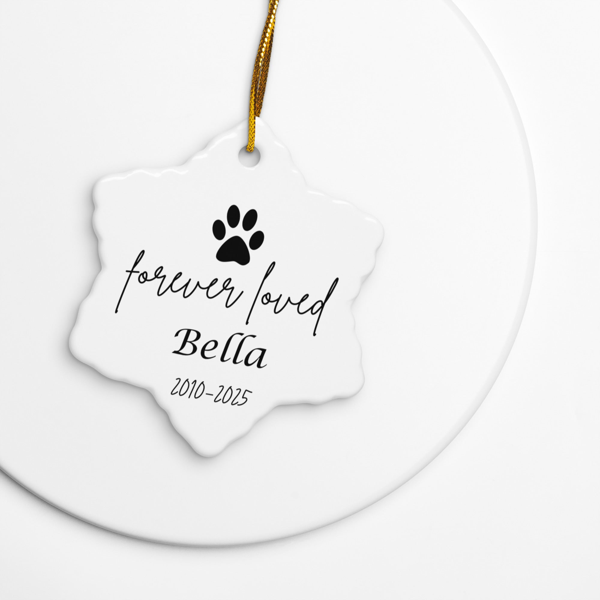 White ceramic ornament with black paw print and text on a white background